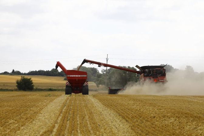 Traktor mit Überladewagen sowie Mähdrescher