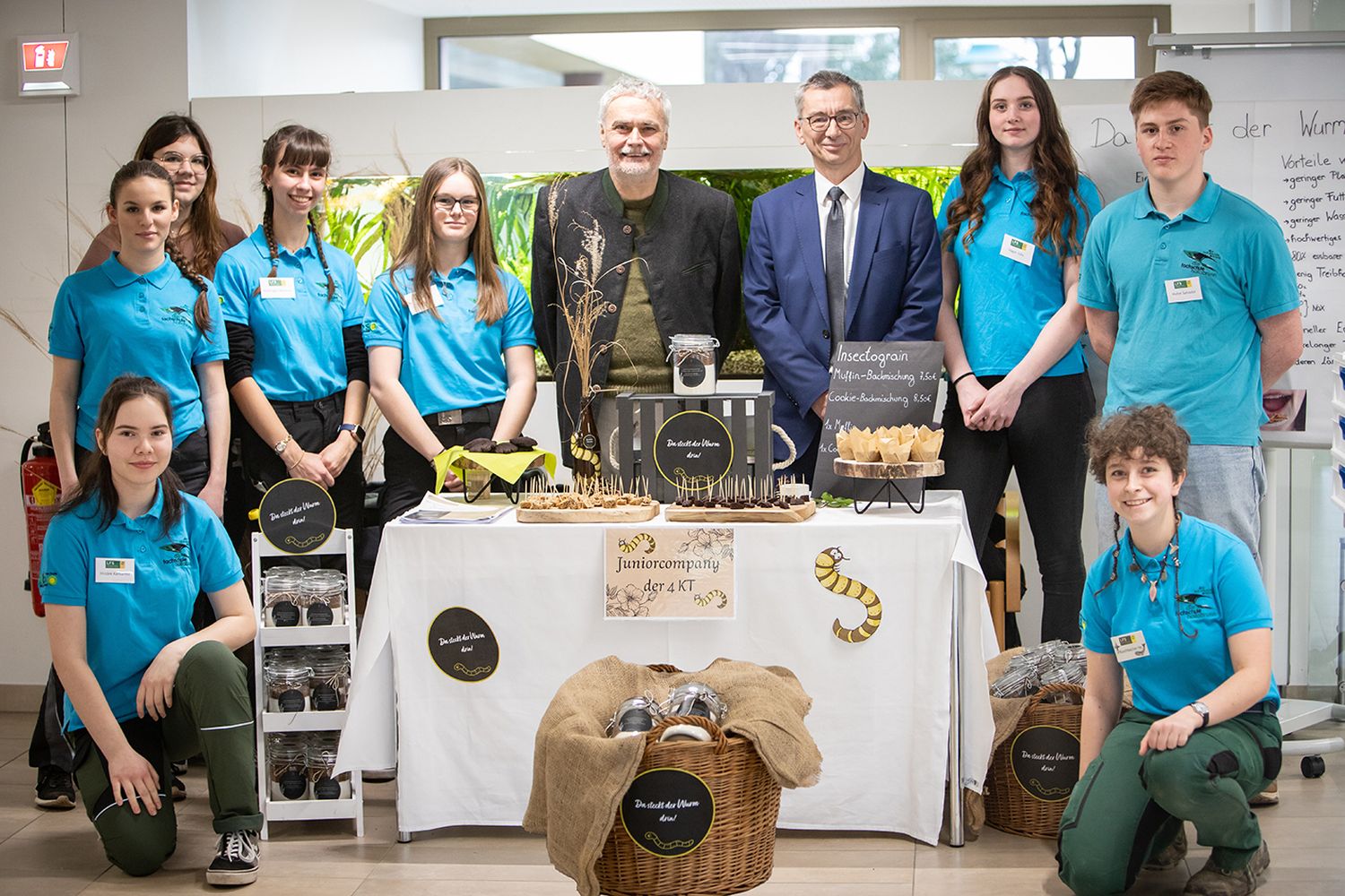 Die Schülerinnen und Schüler von Insectograin vor ihrem Verkaufsstand bei der Handelsmesse in Wien Mitte mit Direktor Rudolf Reisenberger und Prokurist Franz Kraus.