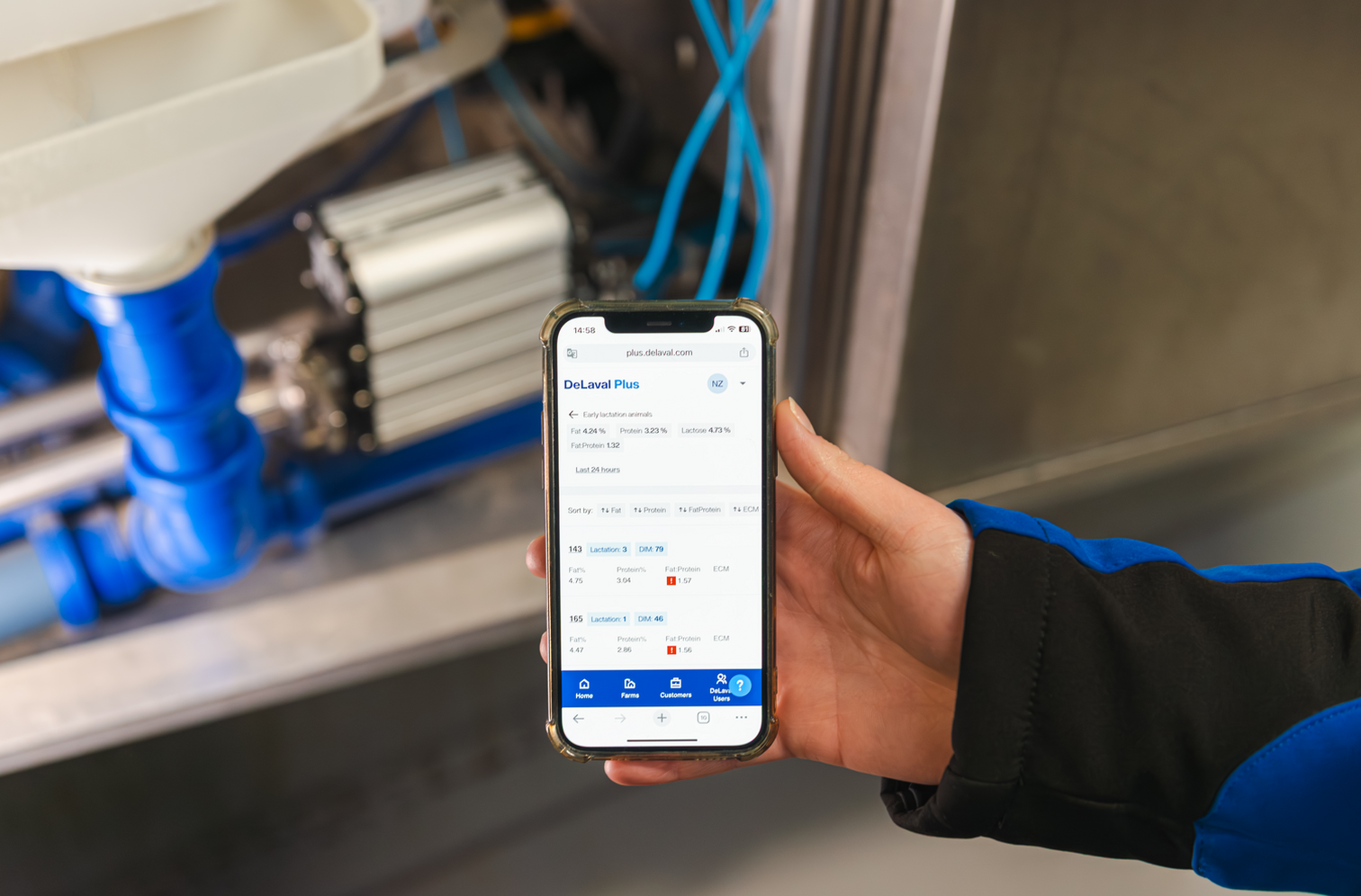 Sensor im Hintergrund, Milchfeststoffanalyse in DeLaval Plus auf dem Smartphone
