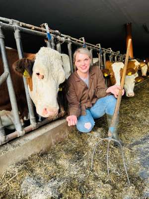 Bäuerin im Stall mit Kühen