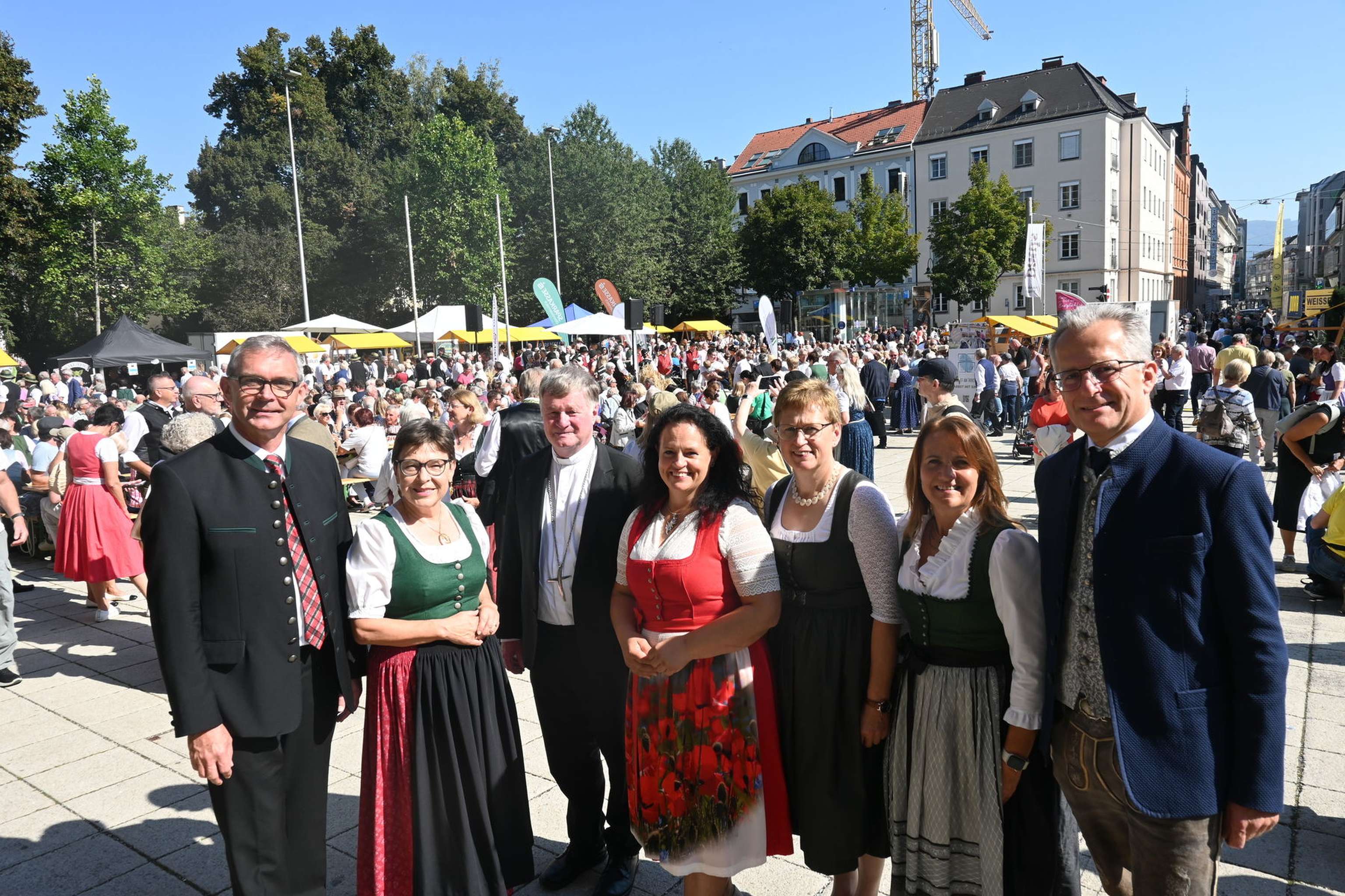 Organisatoren mit Bischof Manfred Scheuer, im Hintergrund der mit Menschen gefüllte Linzer Domplatz.