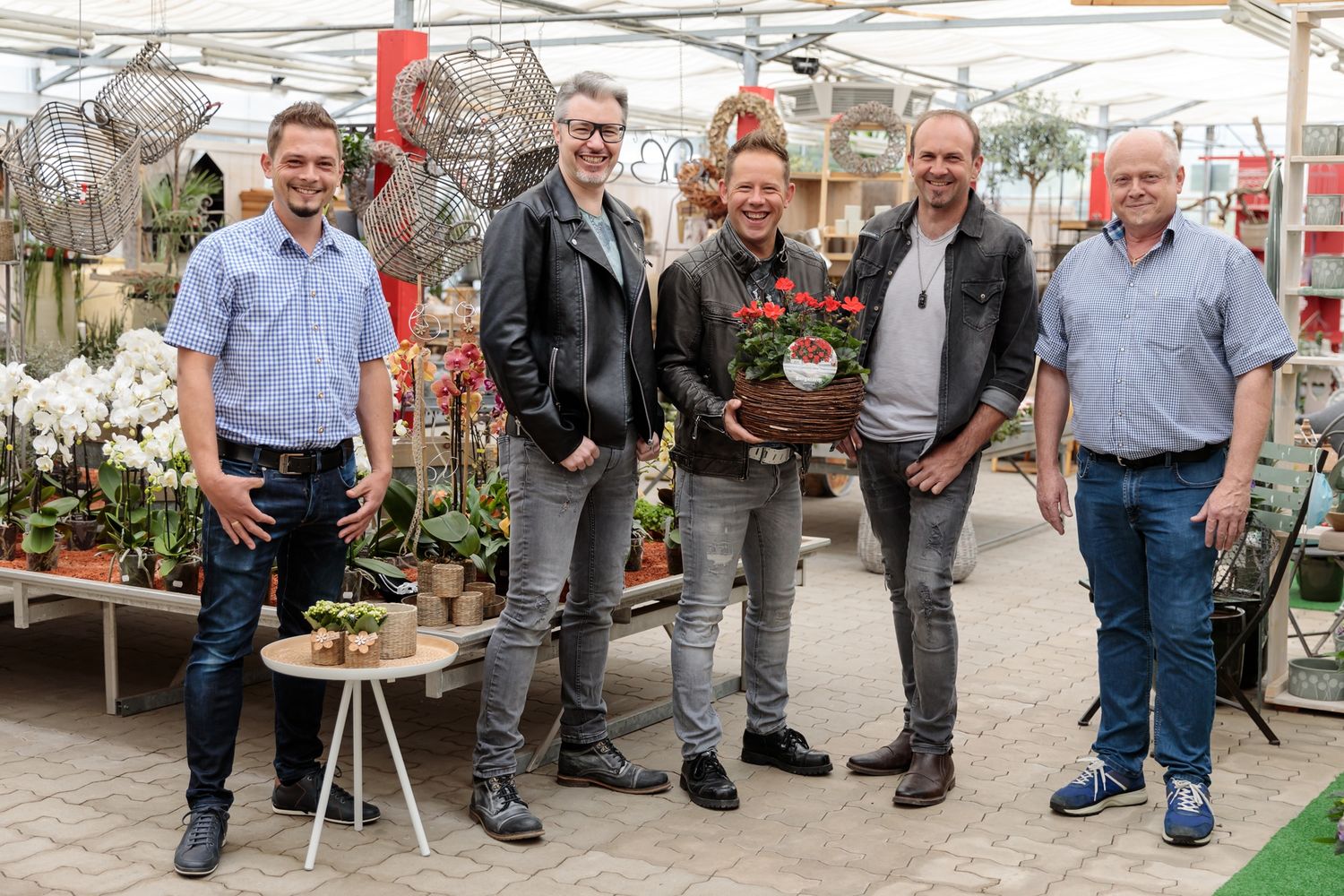 Josef Norz jun., die Musikgruppe Bergalarm und Josef Norz sen. (Blumenwelt Norz-Tichoff) sind begeistert von der „Blume des Jahres“.