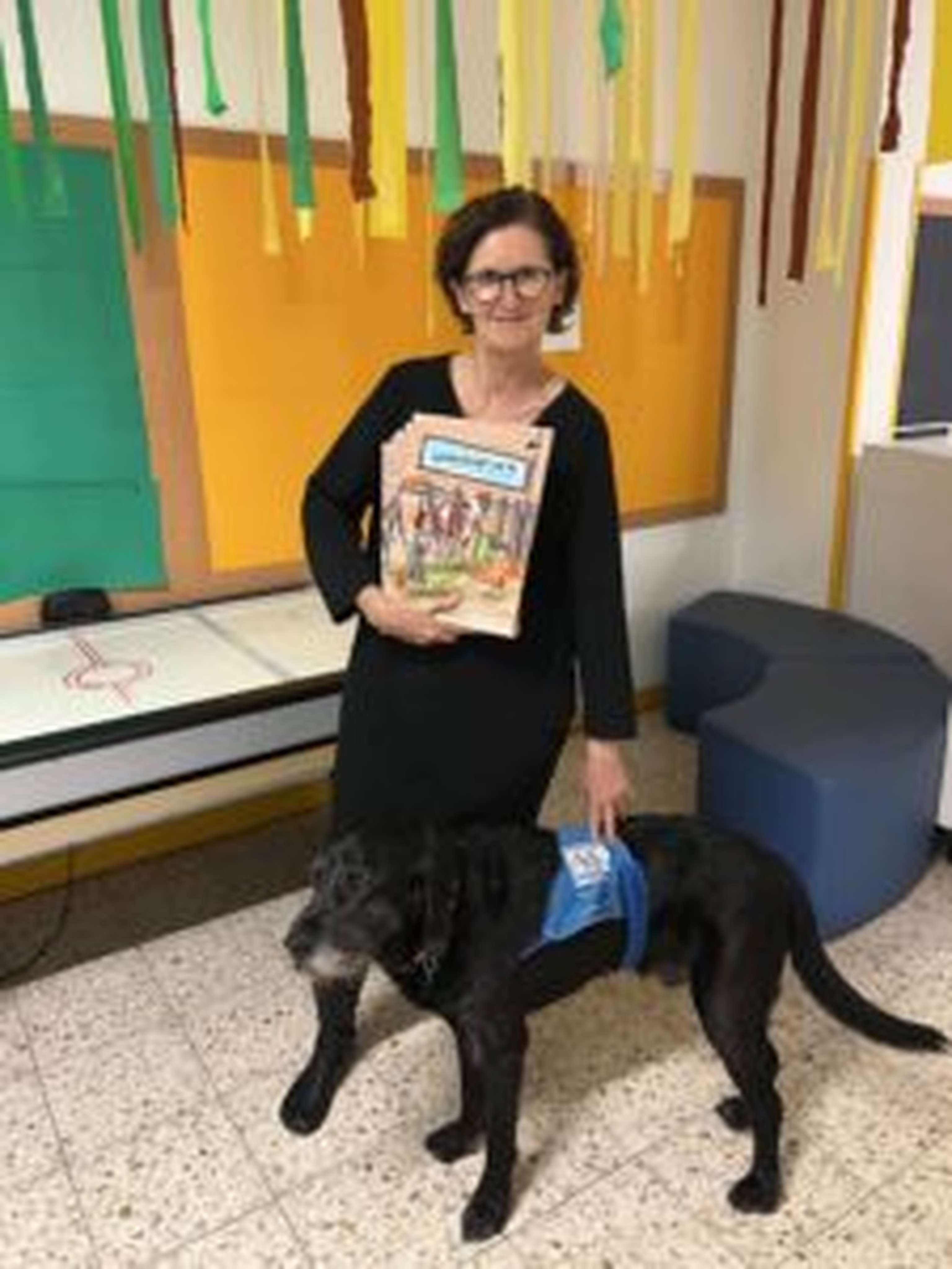 Lehrerin Petra Meixner mit Betreuungshund und Lehrbuch über Landwirtschaft in ihrer Ganztagsschule im 3. Wiener Gemeindebezirk.