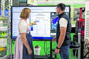 Frau und Mann stehen vor einem Bildschirm für Smart Farming