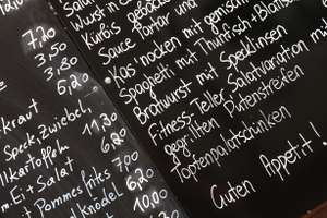 Tafel mit Speisen und Preisen in einem Lokal