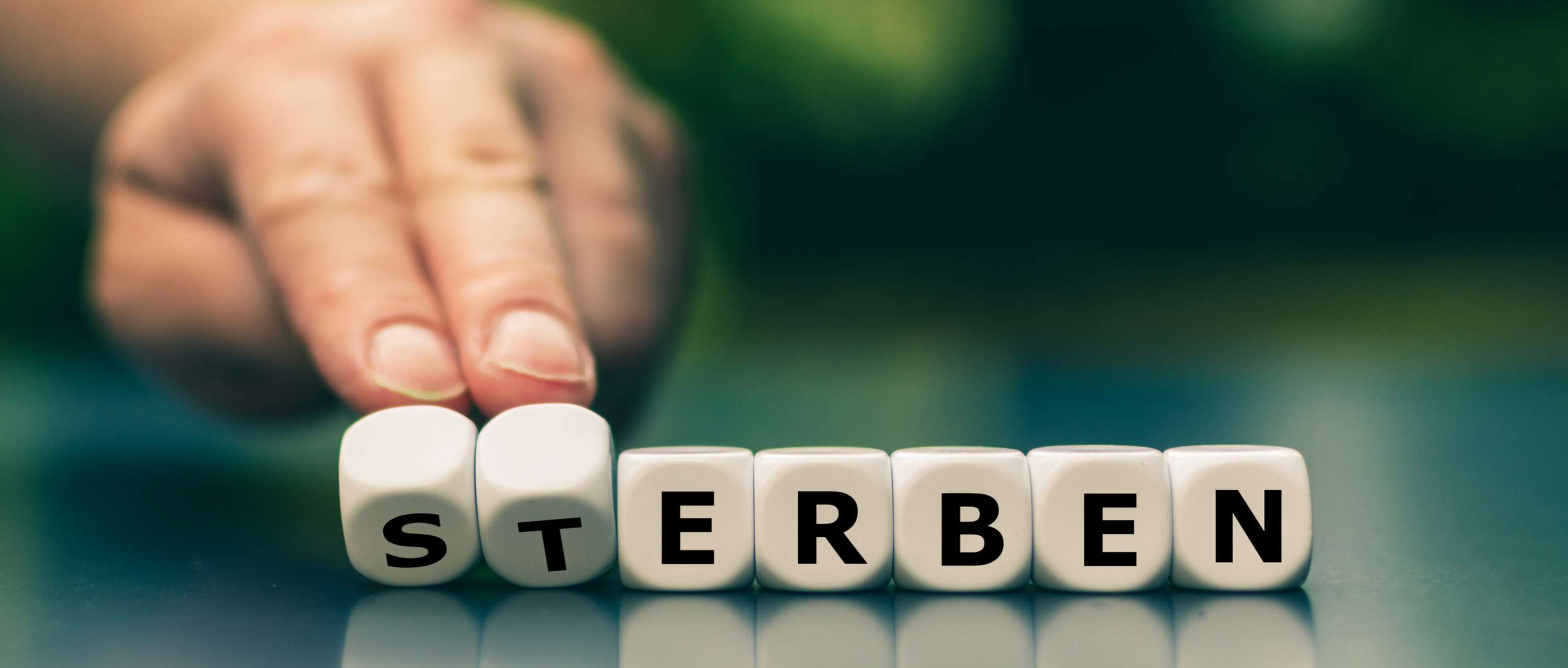 Hand Dreht Würfel Und ändert Das Wort “Sterben” In “Erben”.
