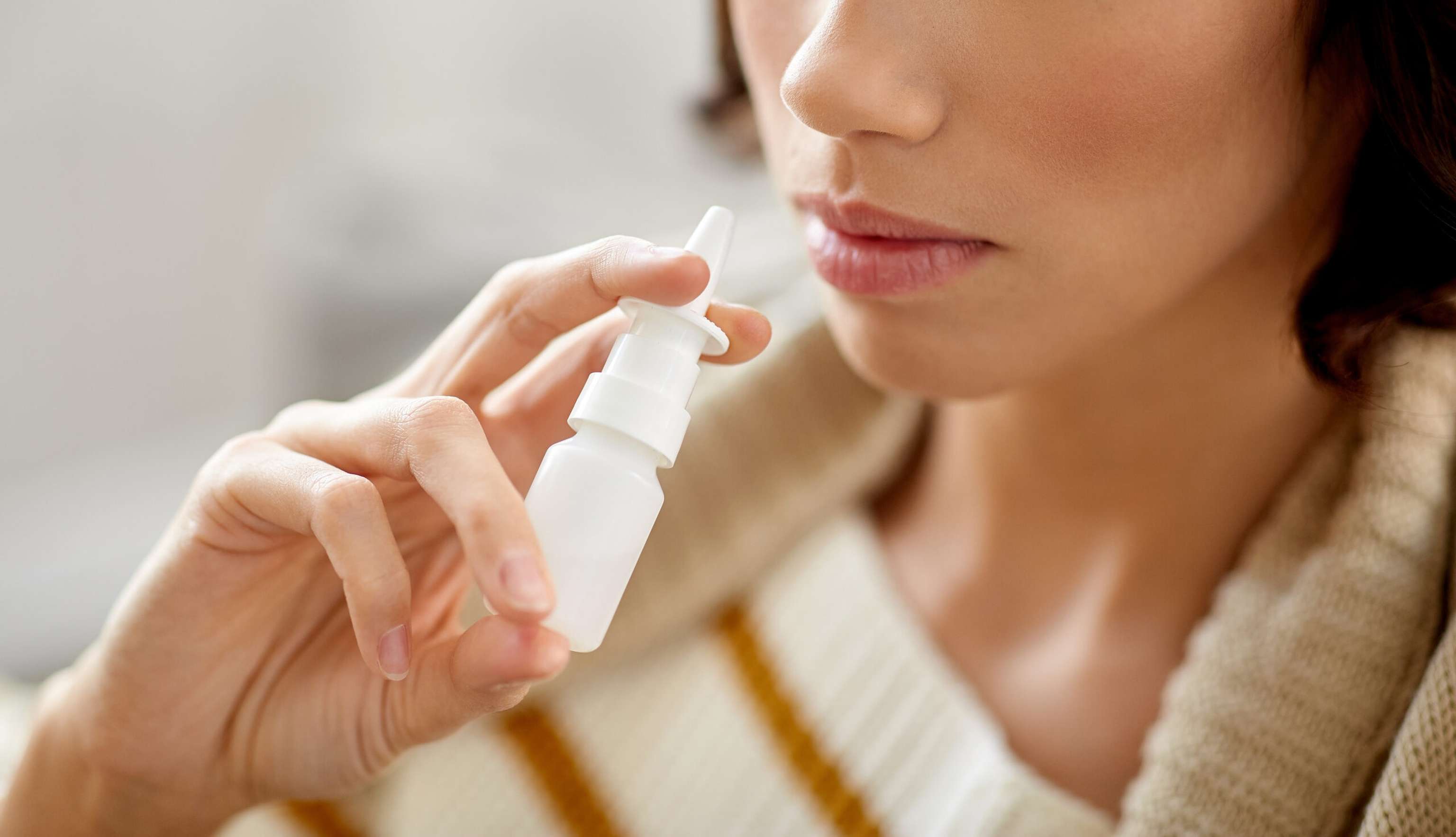 Close Up Of Sick Woman Using Nasal Spray
