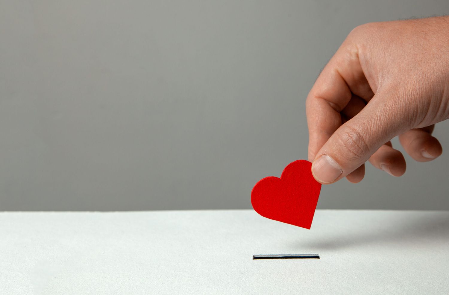 Man’s Hand Places Heart In The Donation Slot. The Concept Of T