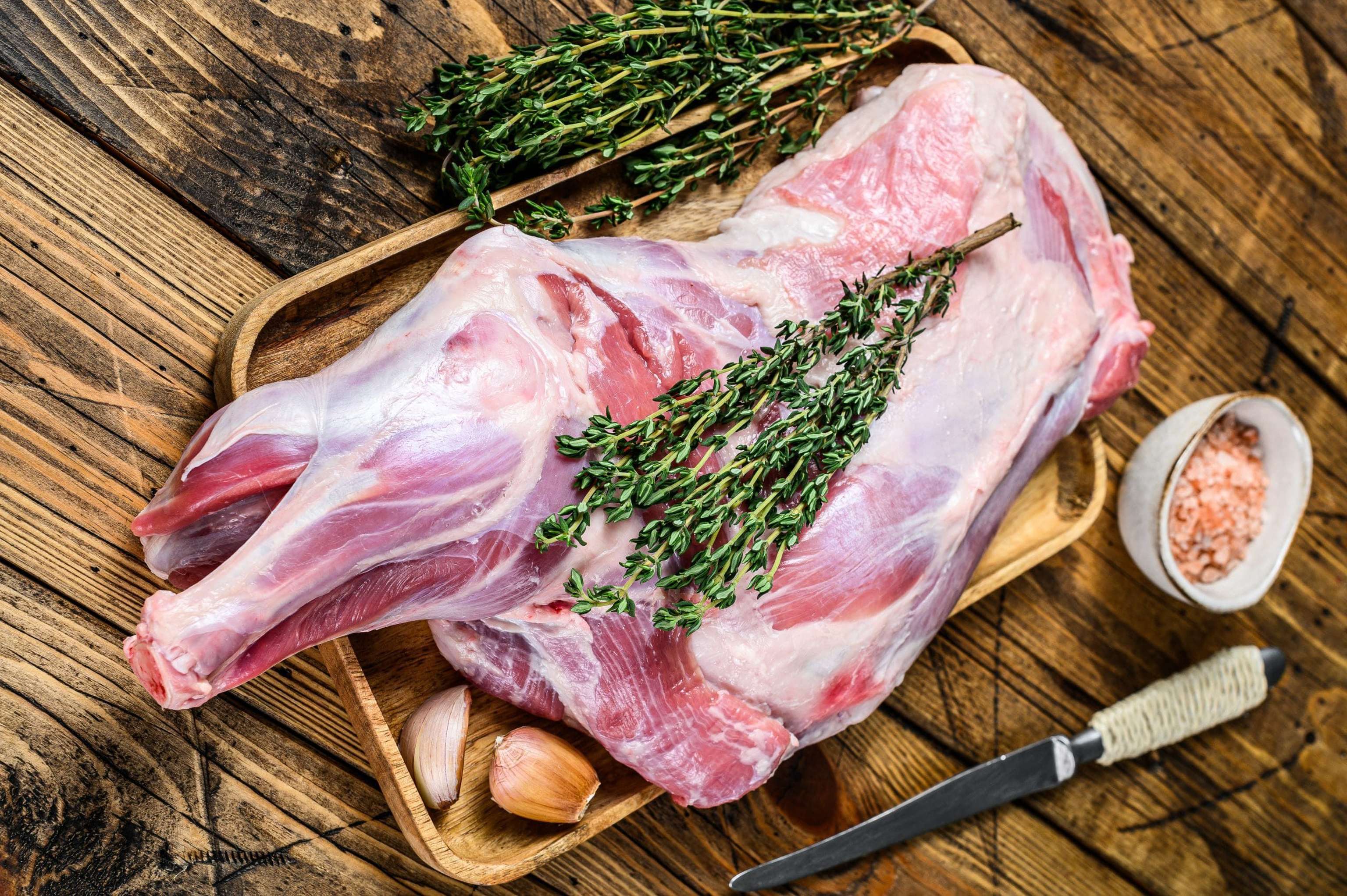 Whole Raw Goat Shoulder Leg Meat On A Wooden Tray. Wooden Background. Top View