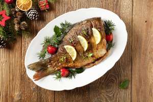Fried Carp Whole. Served With Lemon And Cherry Tomatoes On White