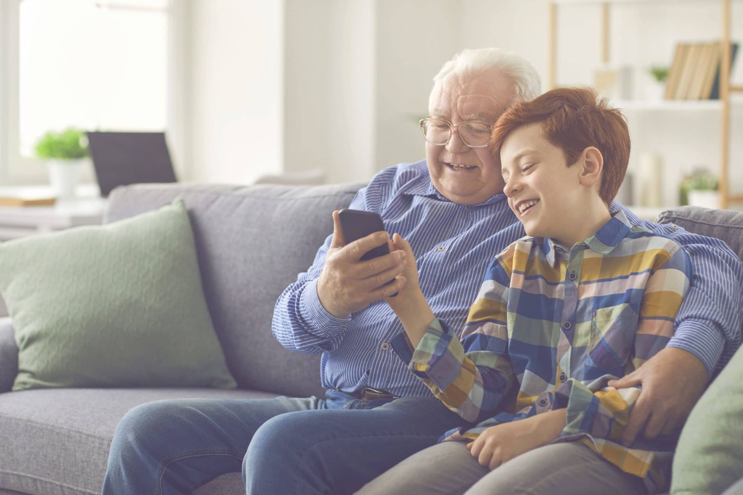 Grandson Showing Grandpa How To Use Social Media Or Make Video Call On Mobile Phone