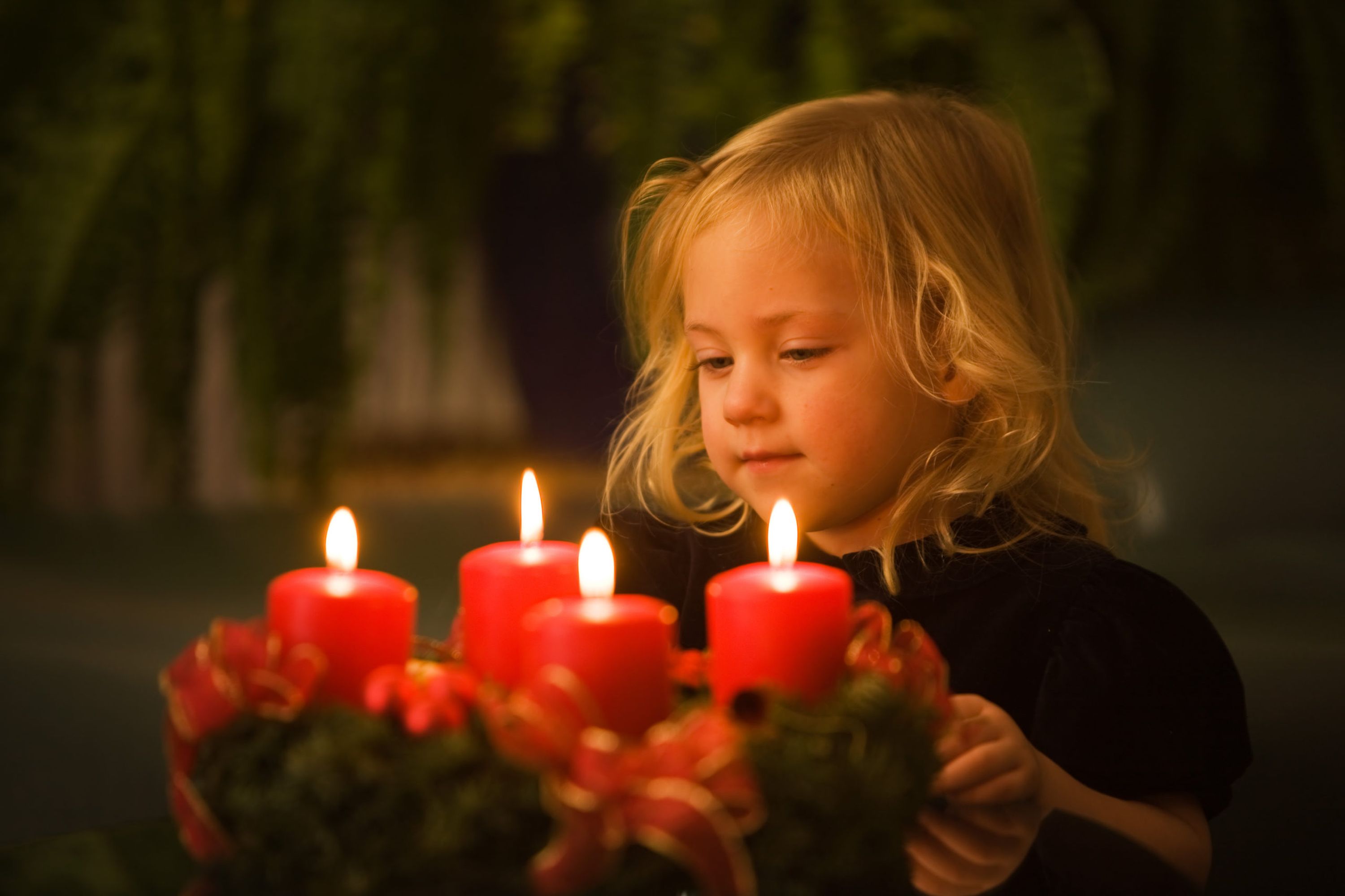 Kind mit Adventkranz zu Weihnachten
