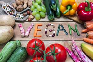 Vegan Word On Wood Background And Vegetable Food