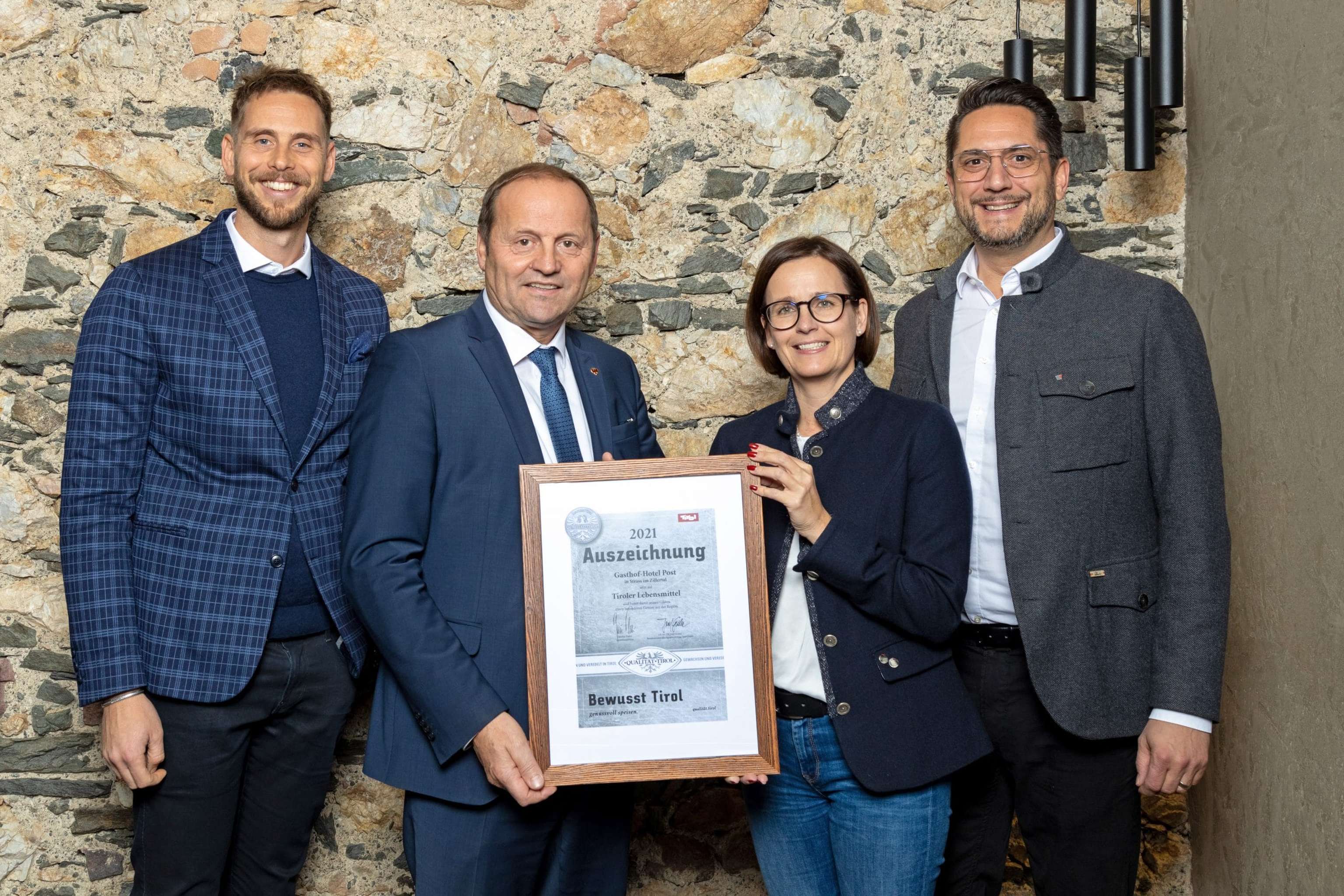 Matthias Pöschl (GF AMTirol) und LH Stv. Josef Geisler übergeben die „Bewusst Tirol“ Auszeichnung an Alois Rainer (Inhaber Hotel Post in Strass i.Z. und Spartenobm.-Stv. WK Tirol, Sparte Tourismus und Freizeitwirtschaft) und seine Frau Christine.