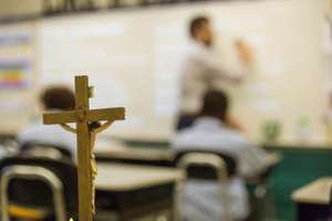 Teacher In Front Of Class During Catholic School Classroom