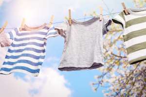 Baby Clothes Hanging On Rope, Isolated On White