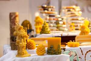 Seasonal Products Sold At Xmas Market. A Close Up View Of Hand Sculpted Wax Candles On A Stall During A Local Seasonal Craft Fair, Festive Decorations For Sale With Copy Space Above.