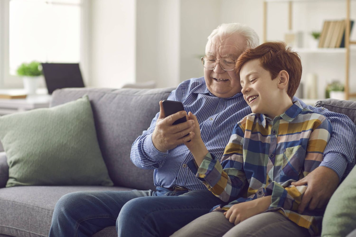 Grandson Showing Grandpa How To Use Social Media Or Make Video Call On Mobile Phone