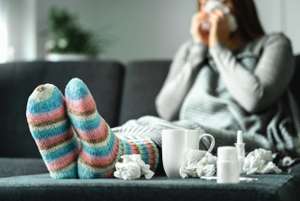 Sick Woman With Flu, Cold, Fever And Cough Sitting On Couch At H