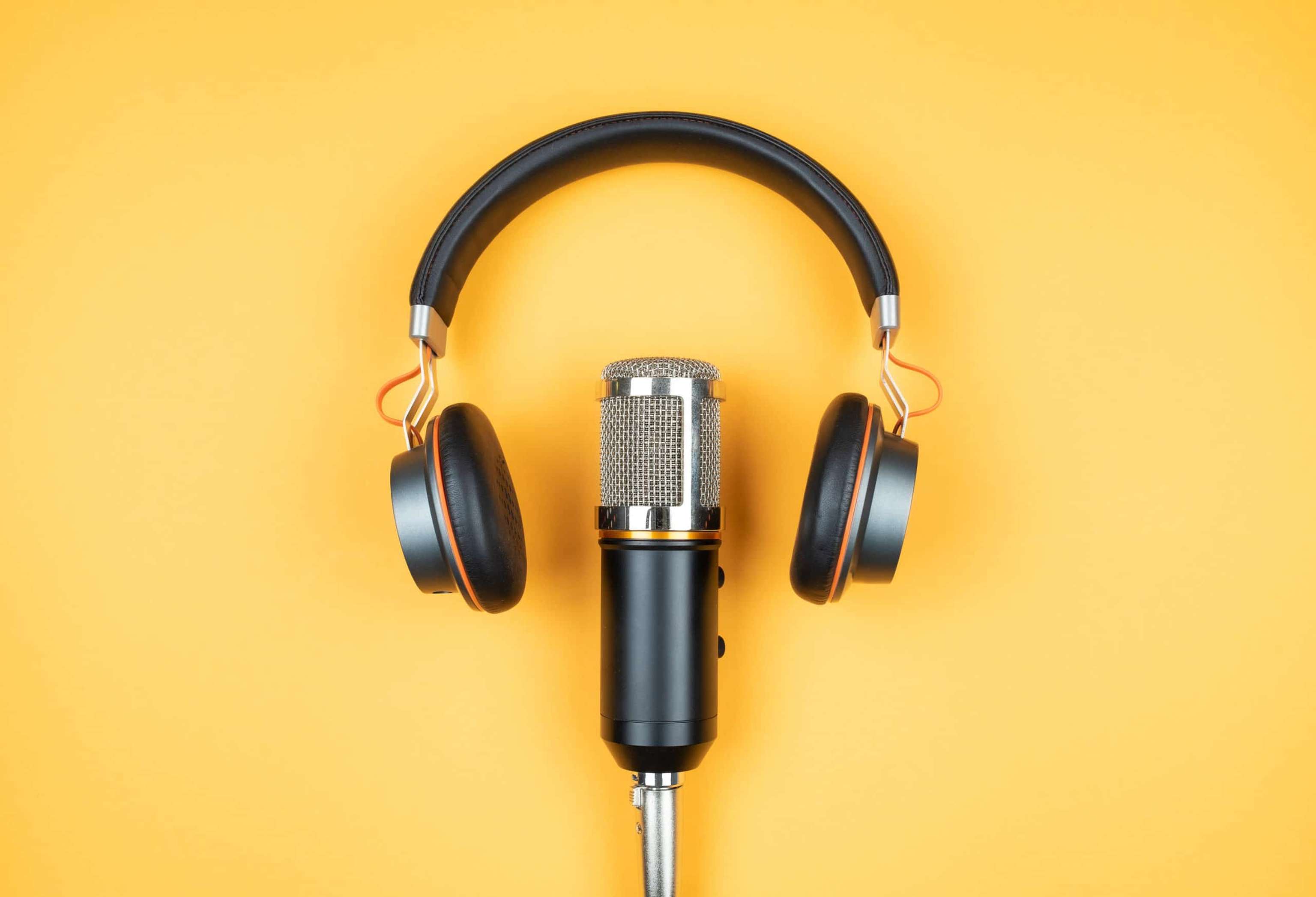 Directly Above View Of Headphones And Recording Microphone On Orange Background