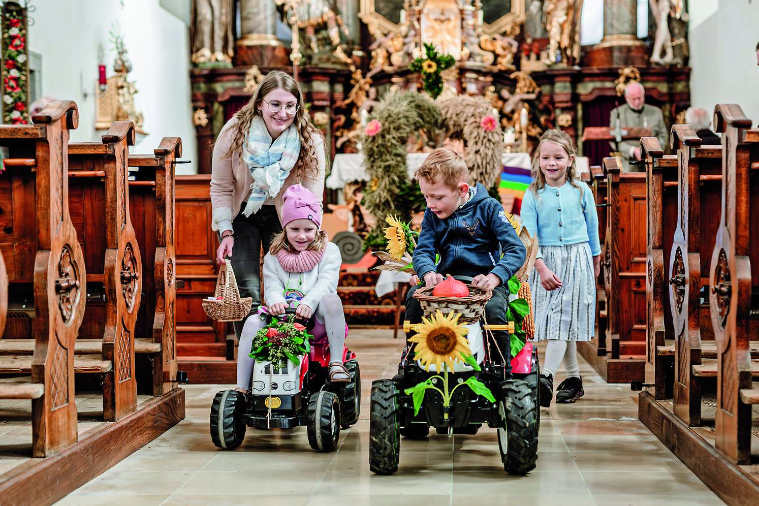 Kinder mit Traktor vor Erntekrone