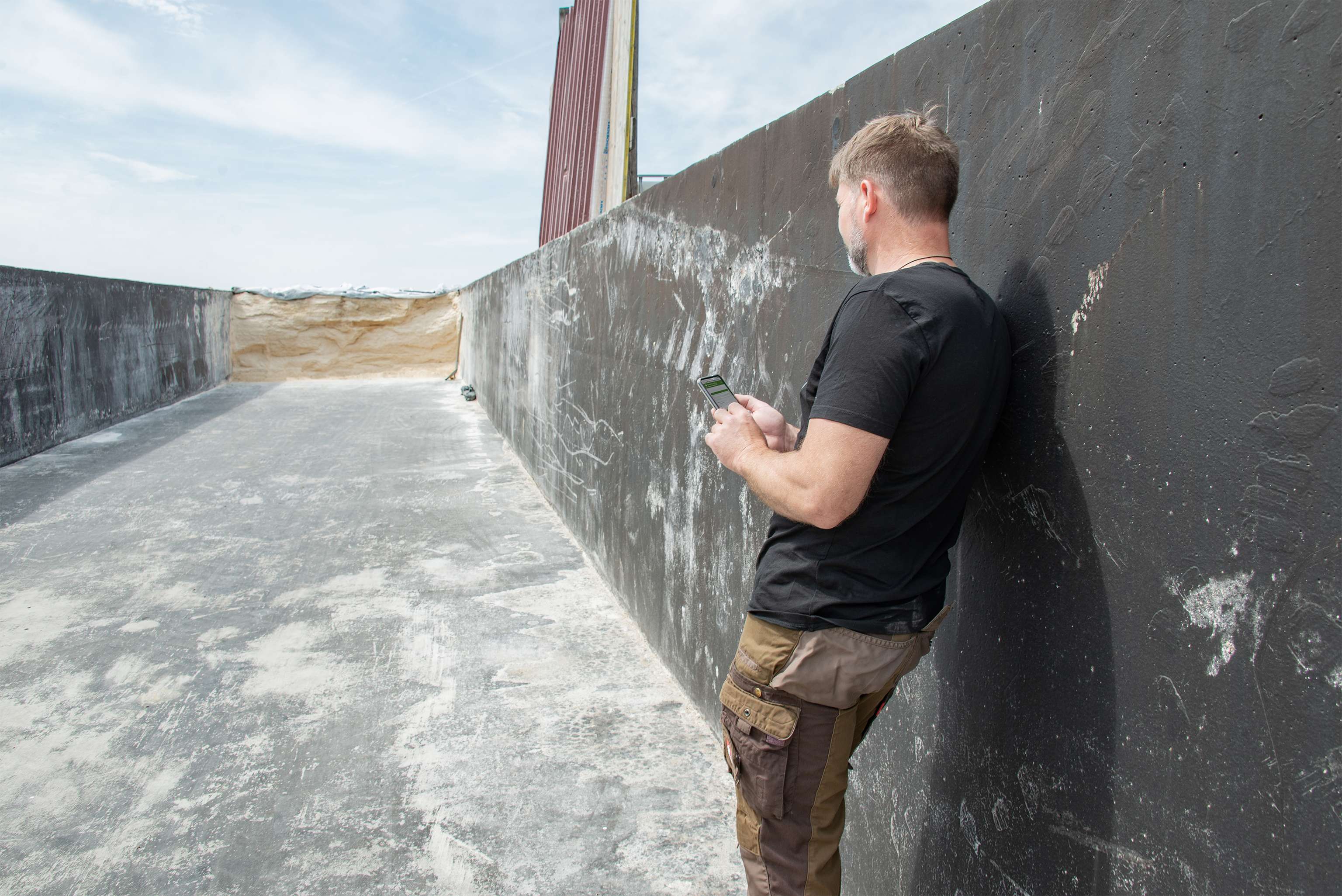 Landwirt bedient Handy, um an der Grundfutterbörse zu handeln.