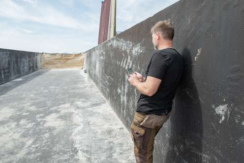 Landwirt bedient Handy, um an der Grundfutterbörse zu handeln.
