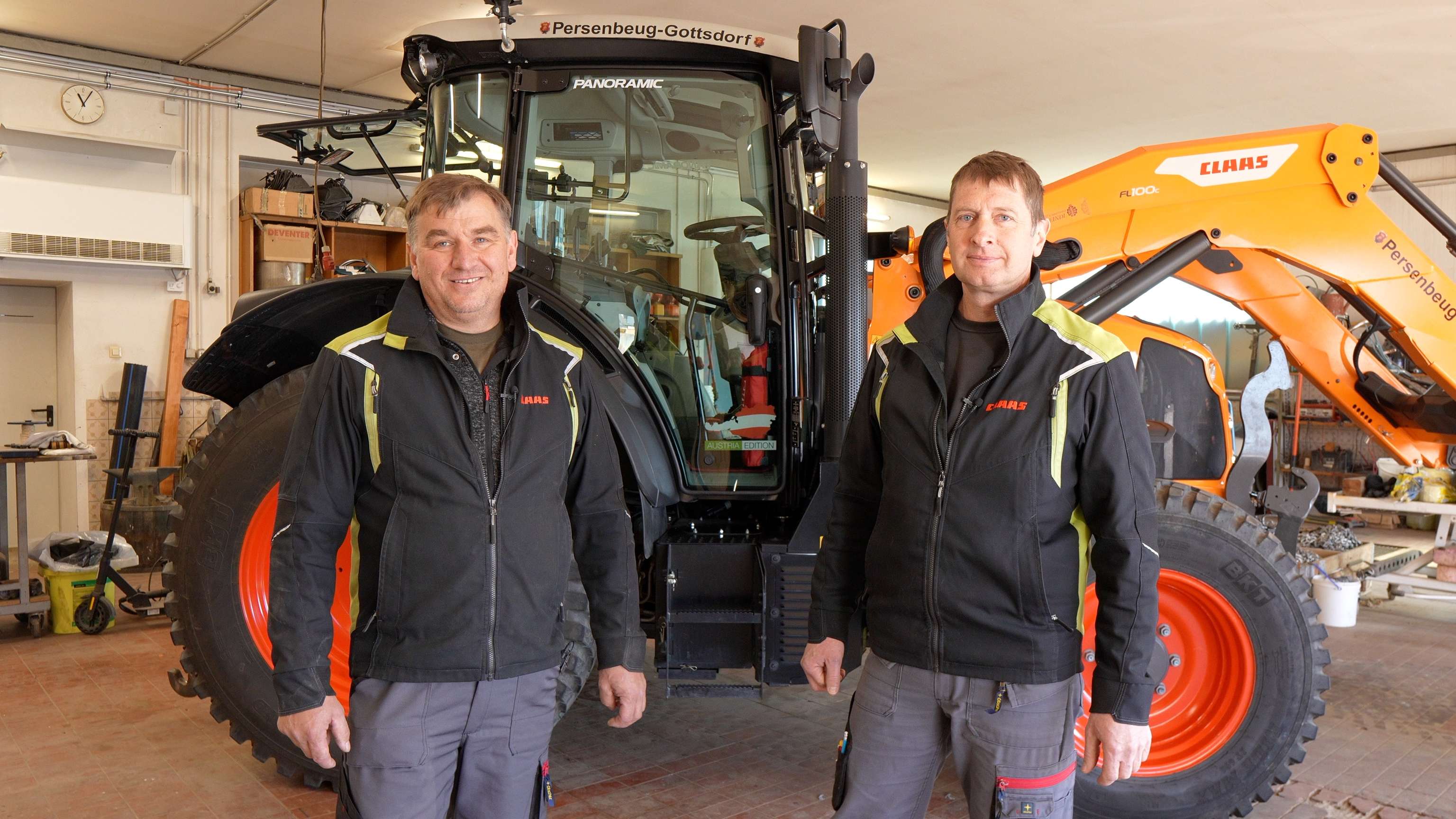 Zwei Männer vor einem Claas-Traktor stehend.