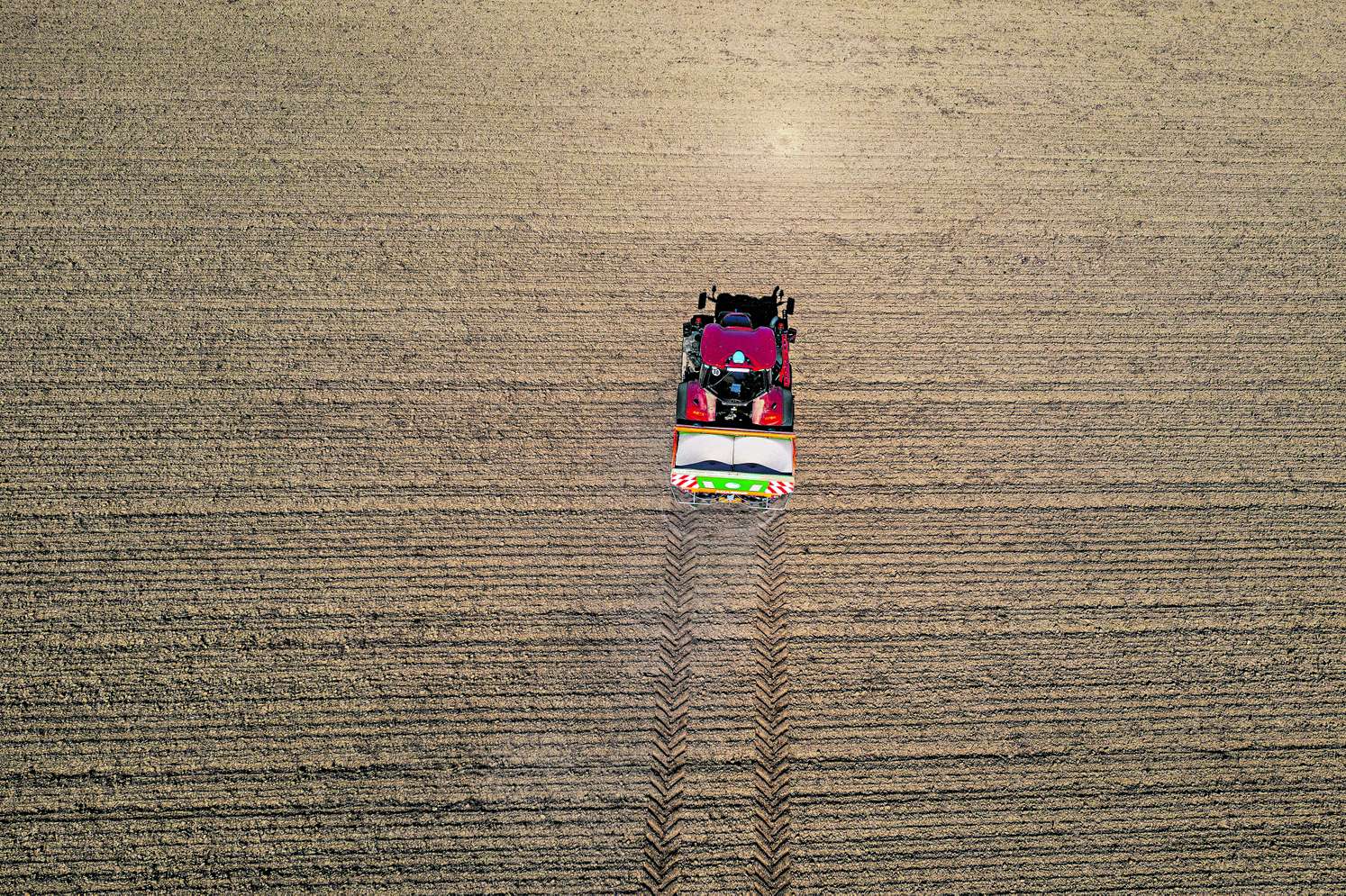 Traktor fährt auf Feld um zu düngen.