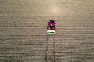 Traktor fährt auf Feld um zu düngen.