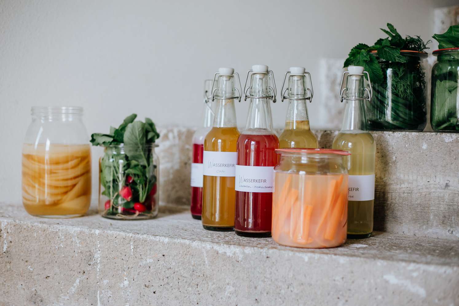 Gläser und Flaschen mit fermentiertem Gemüse und Säften