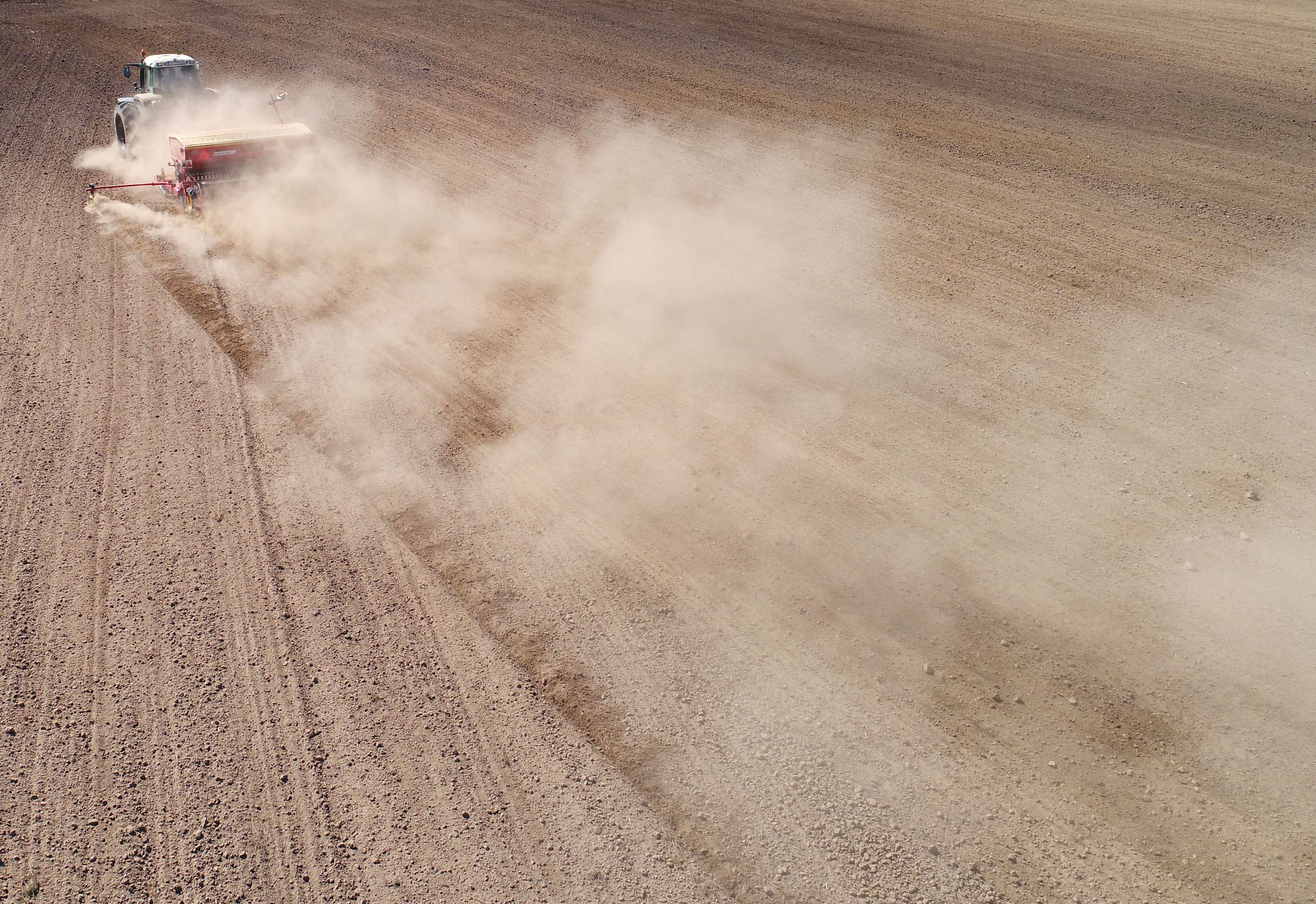 Traktor sät mit Säkombination bei extremer Trockenheit