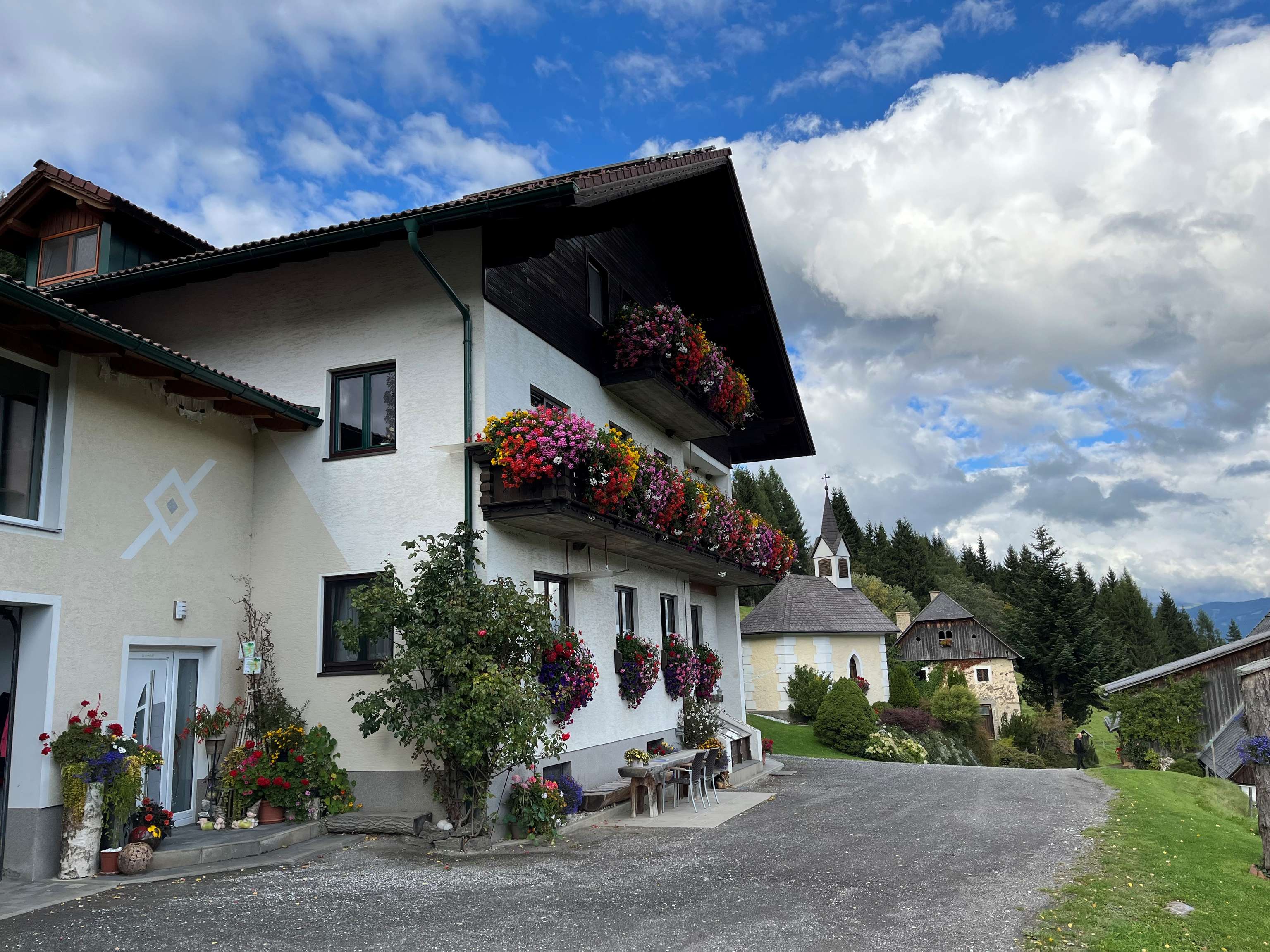 Blumen auf den Balkonen, vor den Fenstern, beim Eingang und im ganzen Hofbereich