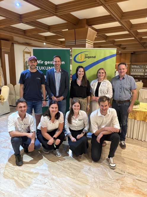 Gruppenfoto von neun Personen vor Landjugend-Rollups in einem Festsaal, zwei Reihen, lächelnd in die Kamera.