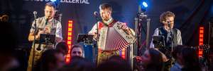 Die Band Sagg'risch aus dem Zillertal spielt live auf der Bühne mit Klarinette und Akkordeon in Tracht.