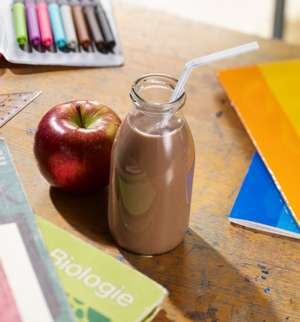 Kakao und ein Apfel liegen am Tisch