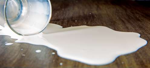 Verschüttete Milch mit Glas