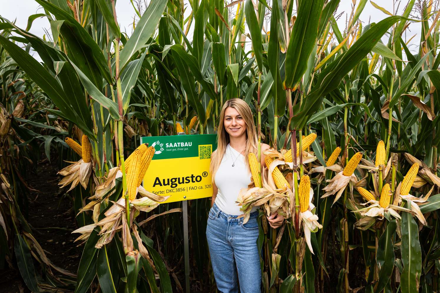 Frau in einem Feld stehend mit Augusto-Schild