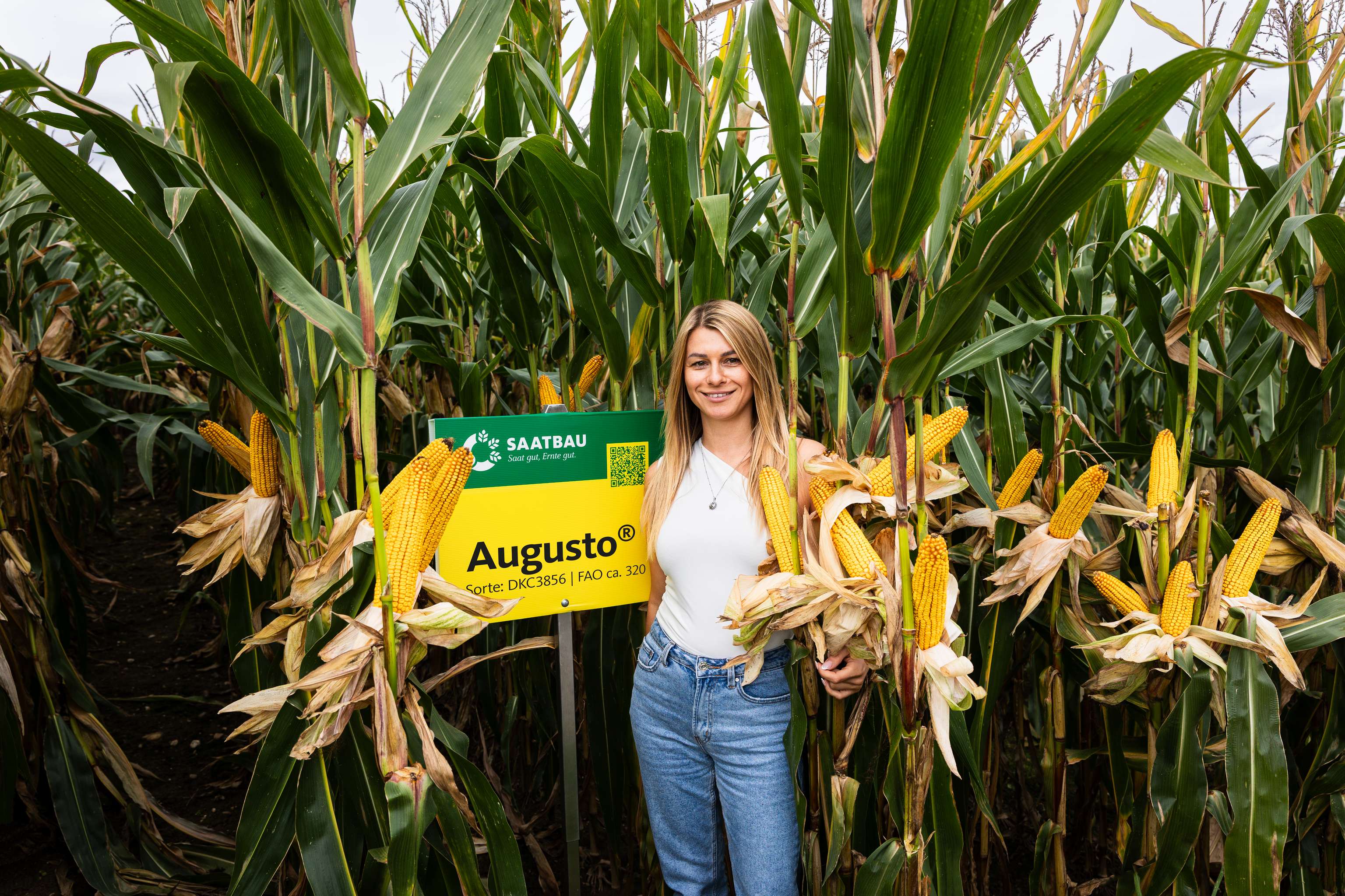 Frau in einem Feld stehend mit Augusto-Schild
