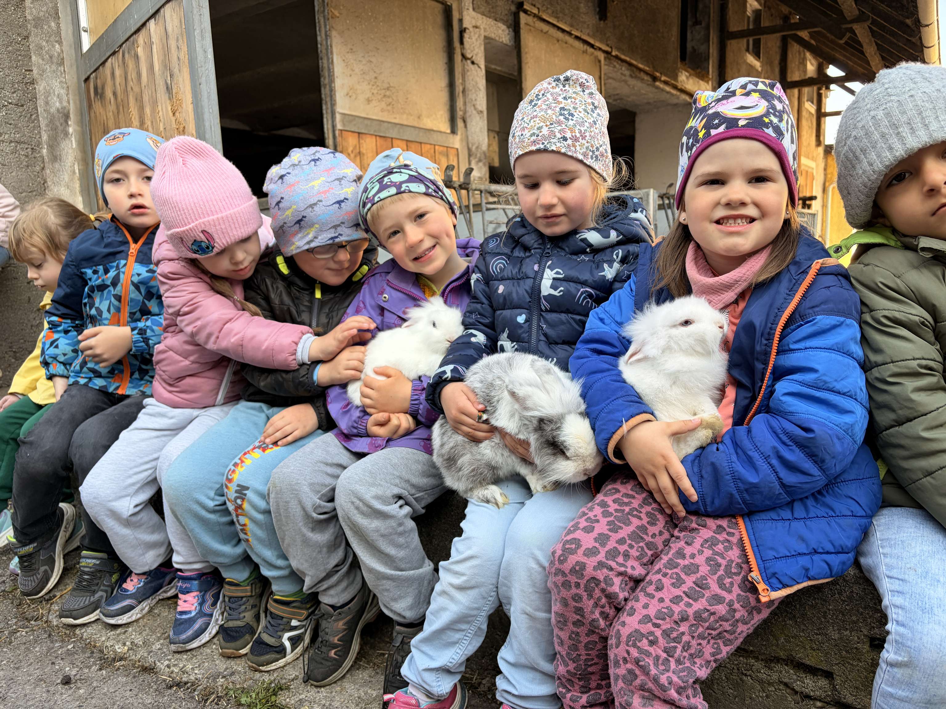 Kinder mit Zwergkaninchen am Schoß.