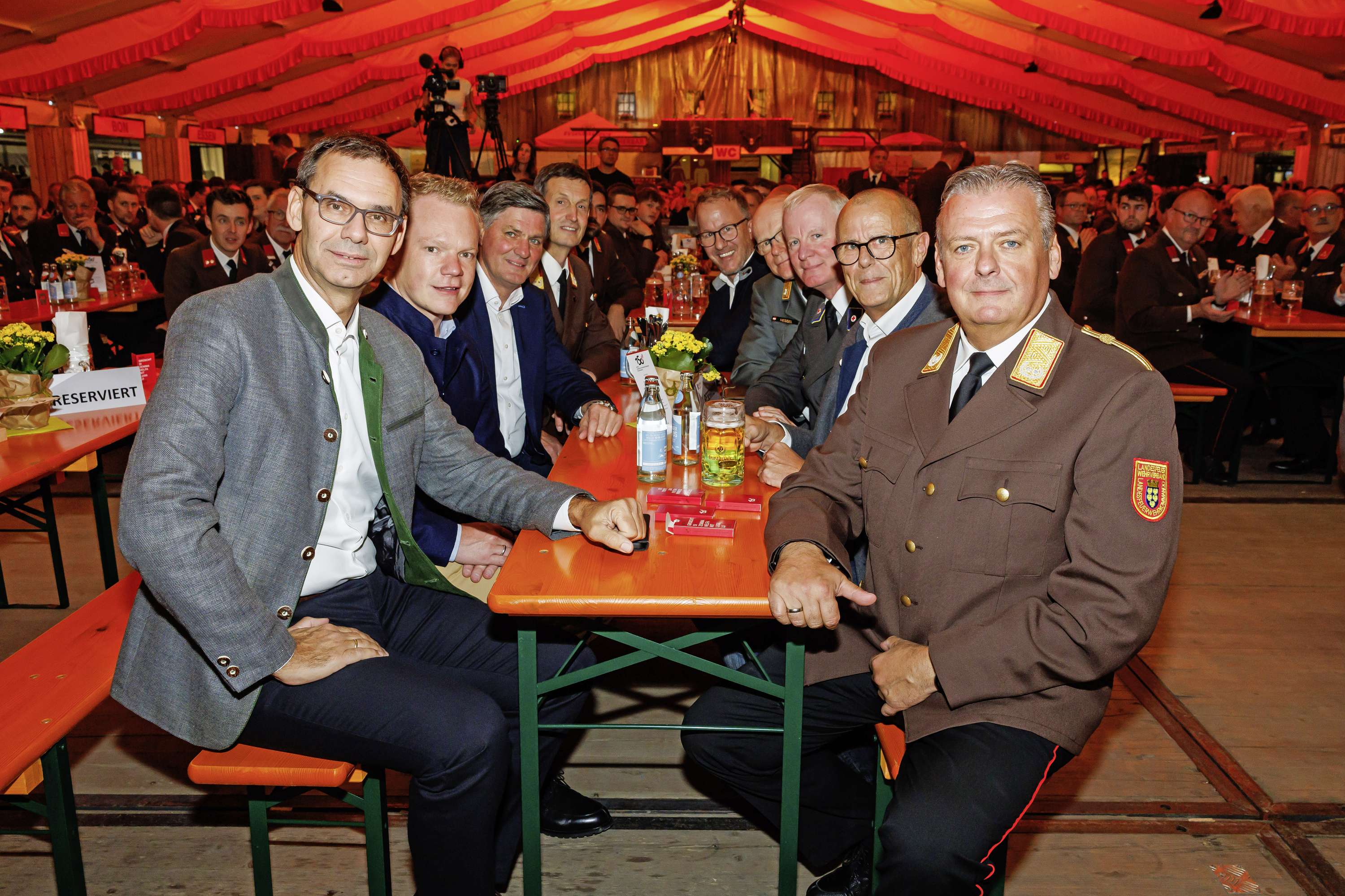 Landeshauptmann Markus Wallner sitzt mit Mitgliedern der Feuerwehr am Tisch
