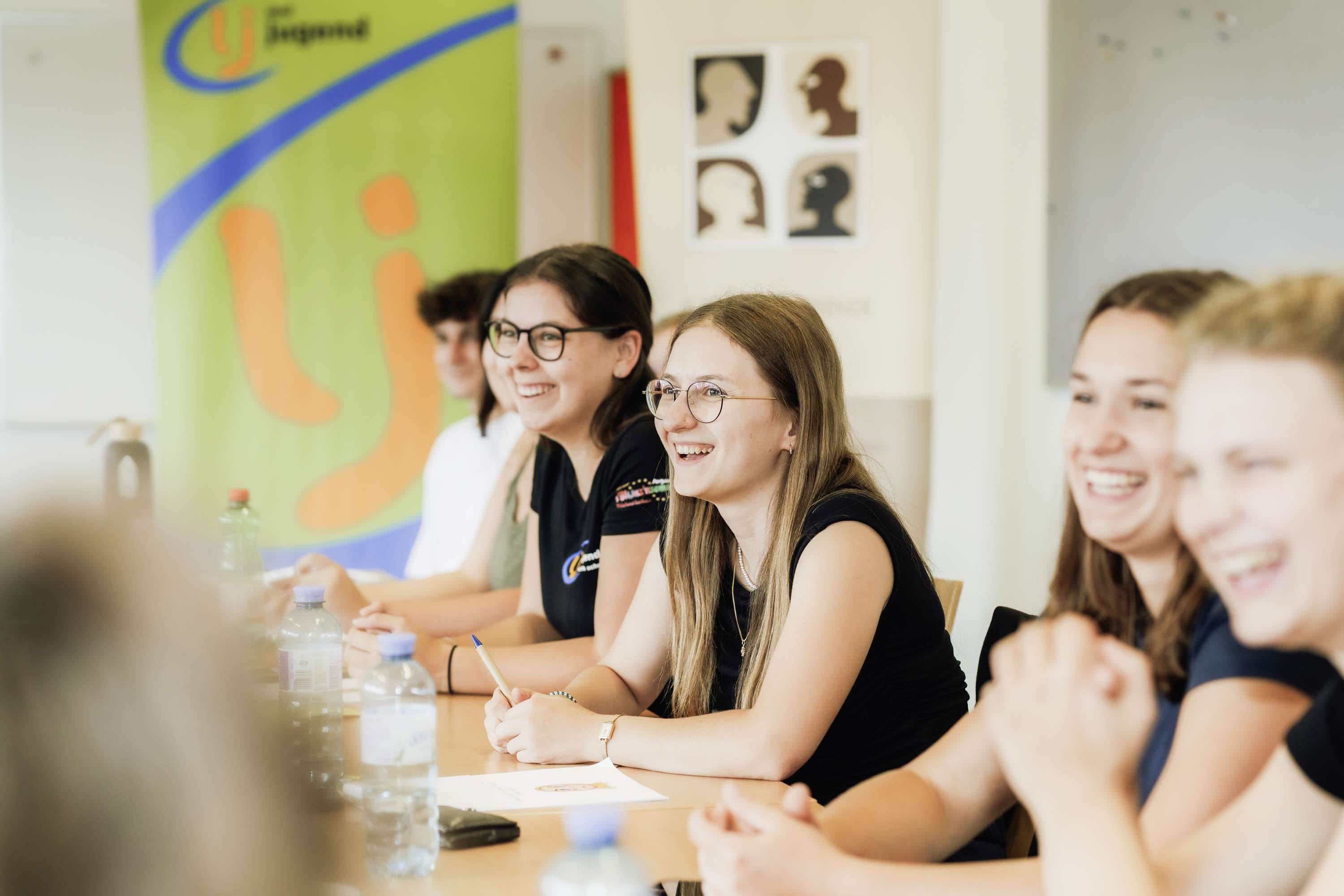 Jugendliche sitzen am Tisch und lachen
