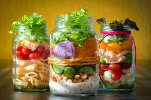 Verschiedene Salate in hohem Glas geschichtet