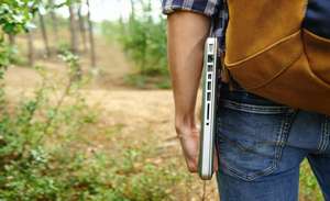 Mann mit Laptop im Wald