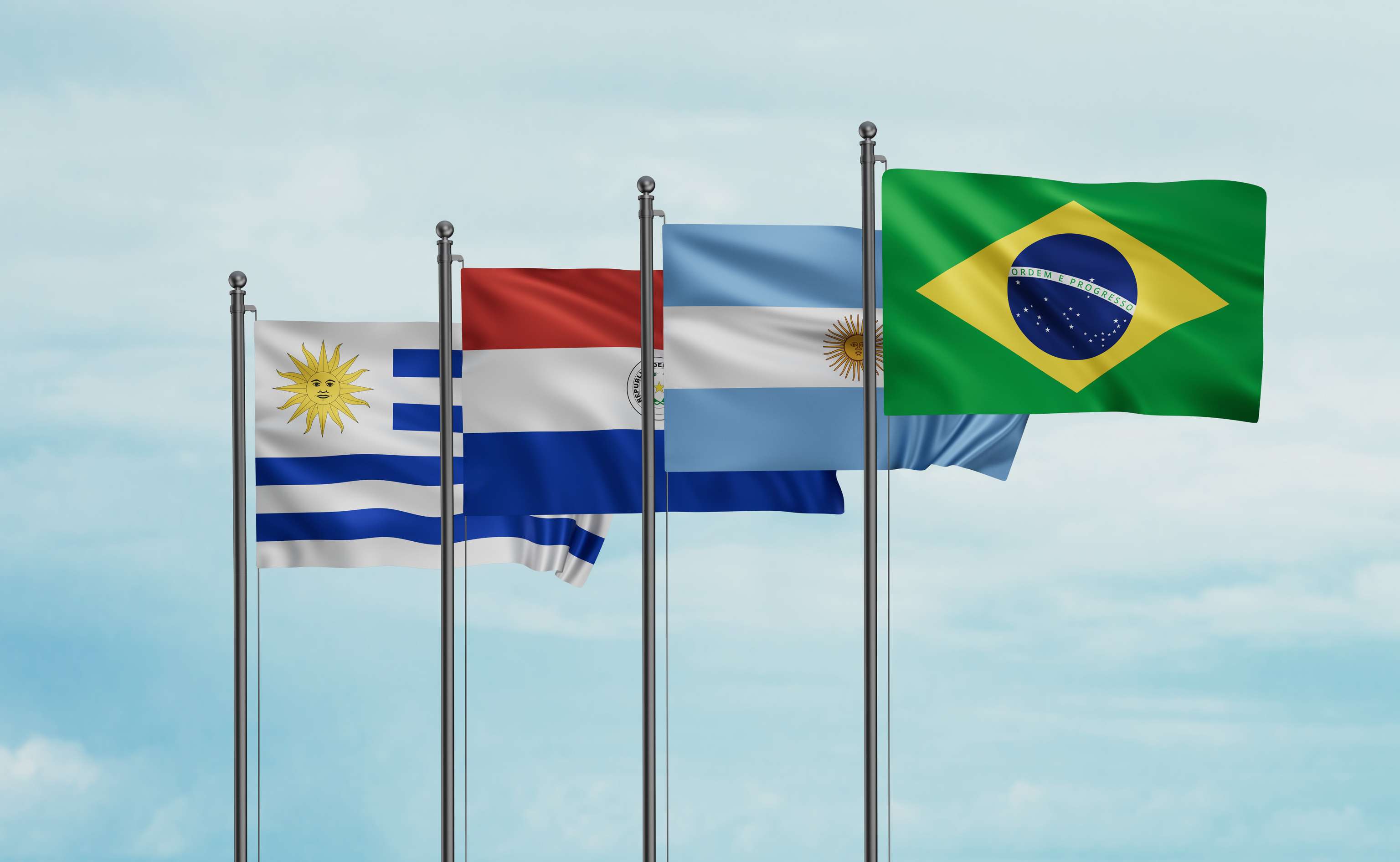 Die Flaggen von Uruguay, Paraguay, Argentinien und Brasilien wehen nebeneinander im Wind