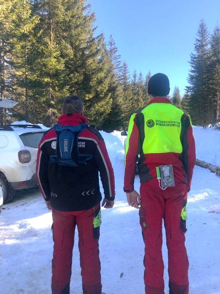 Männer im verschneiten Wald mit Geräten zur Warnung