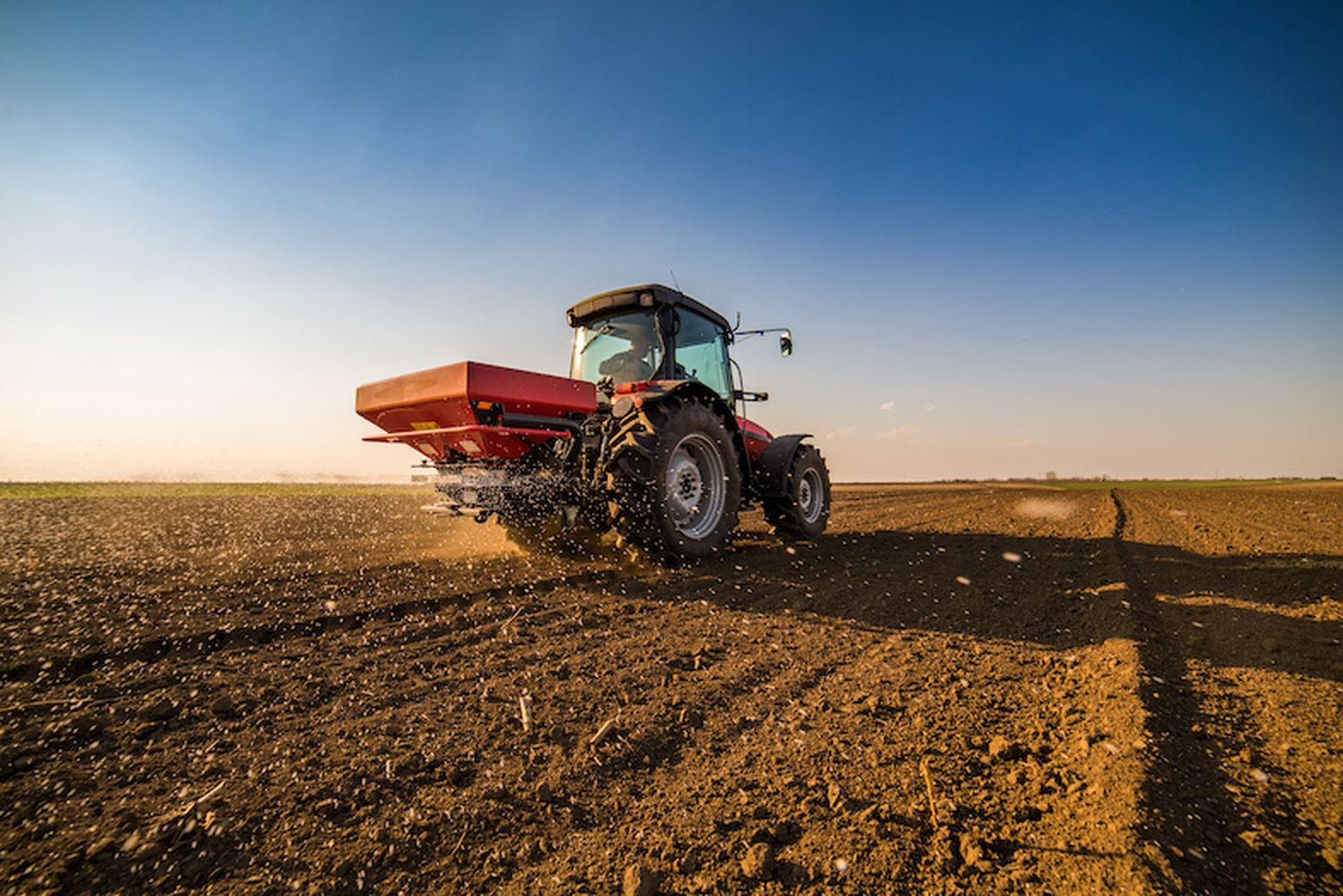 Farmer Fertilizing Arable Land With Nitrogen, Phosphorus, Potassium Fertilizer