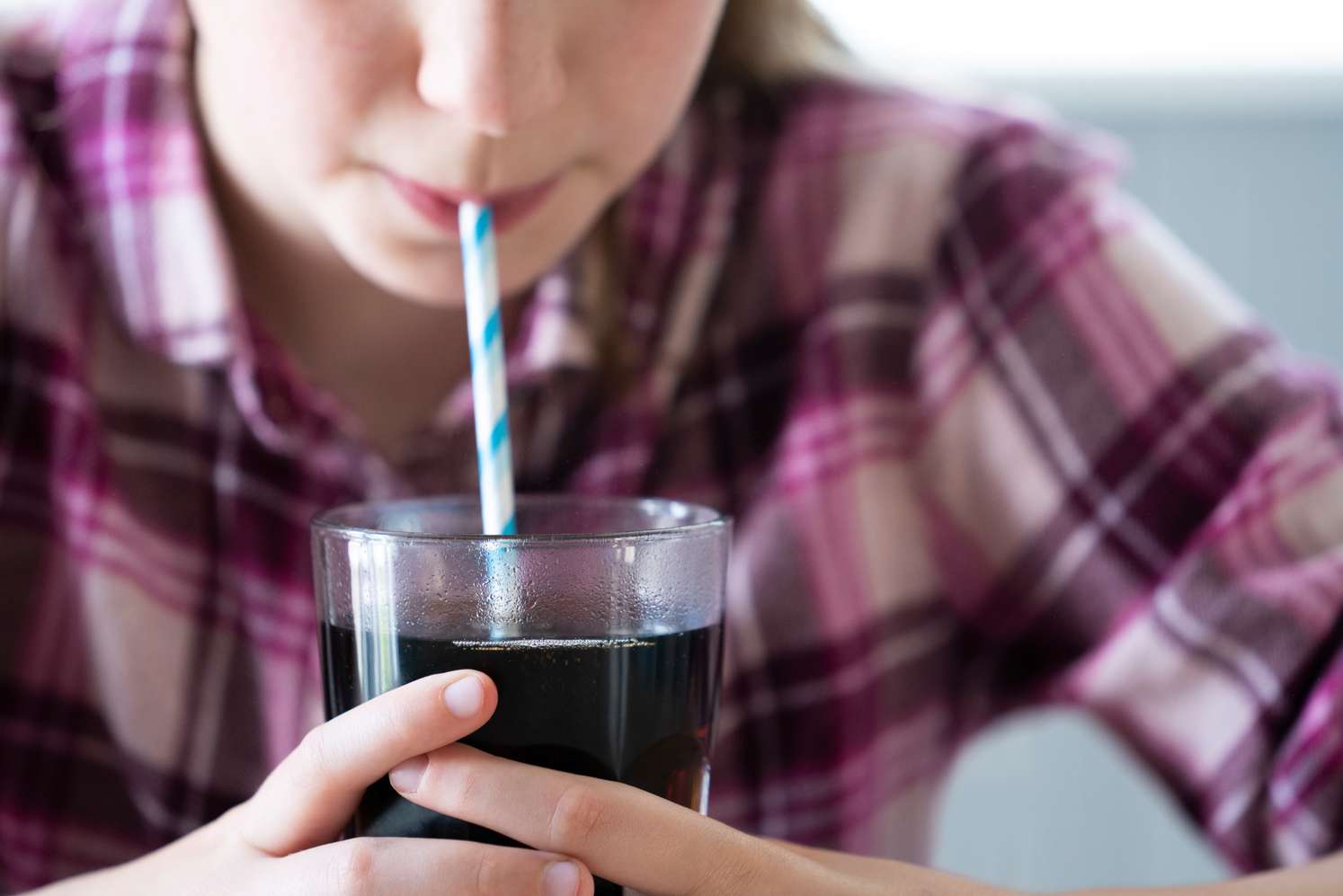 Kind trinkt einen Softdrink mit einem Strohhalm
