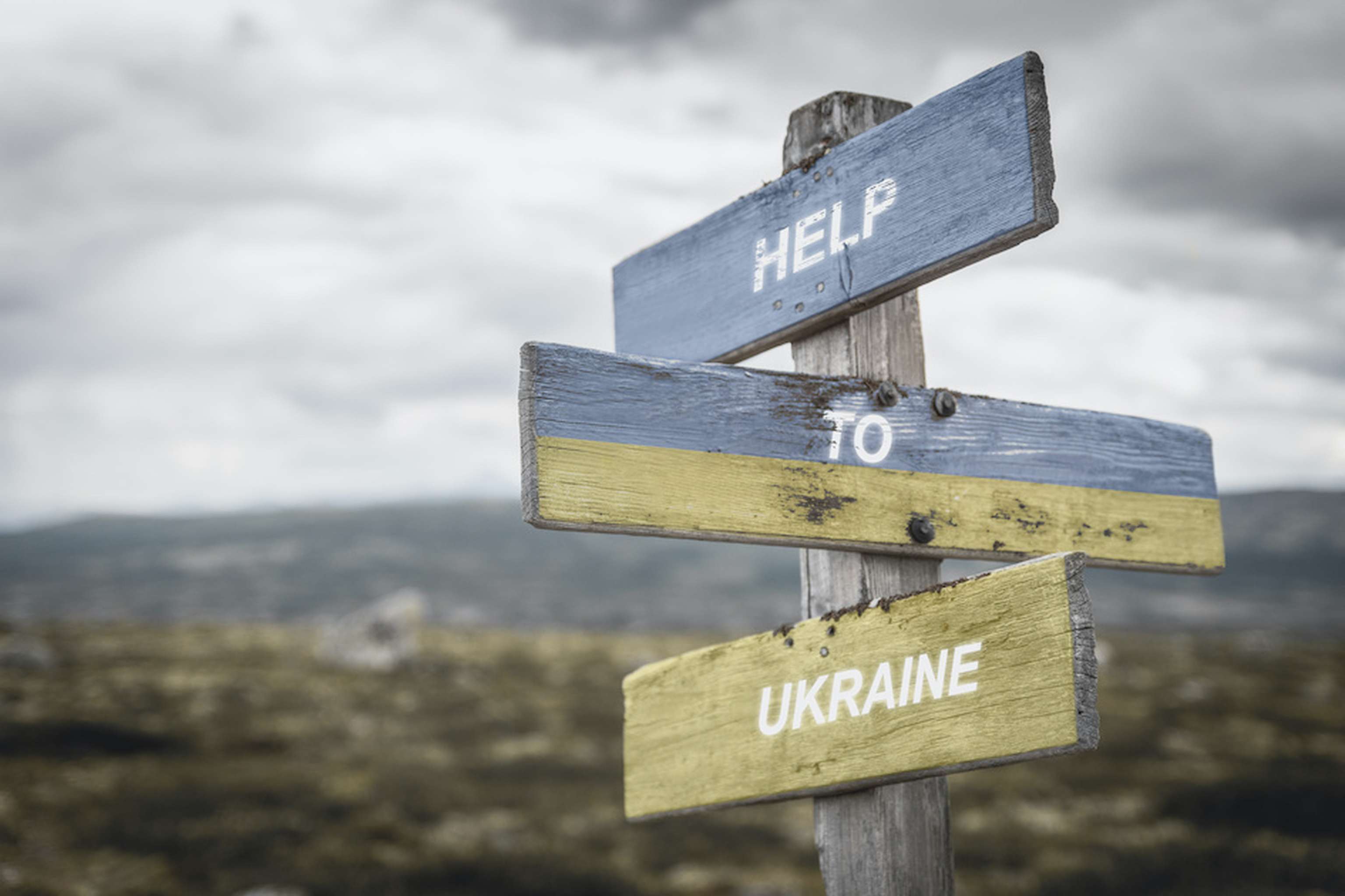 Help To Ukraine Text Quote On Wooden Signpost Outdoors, Written On The Ukranian Flag.