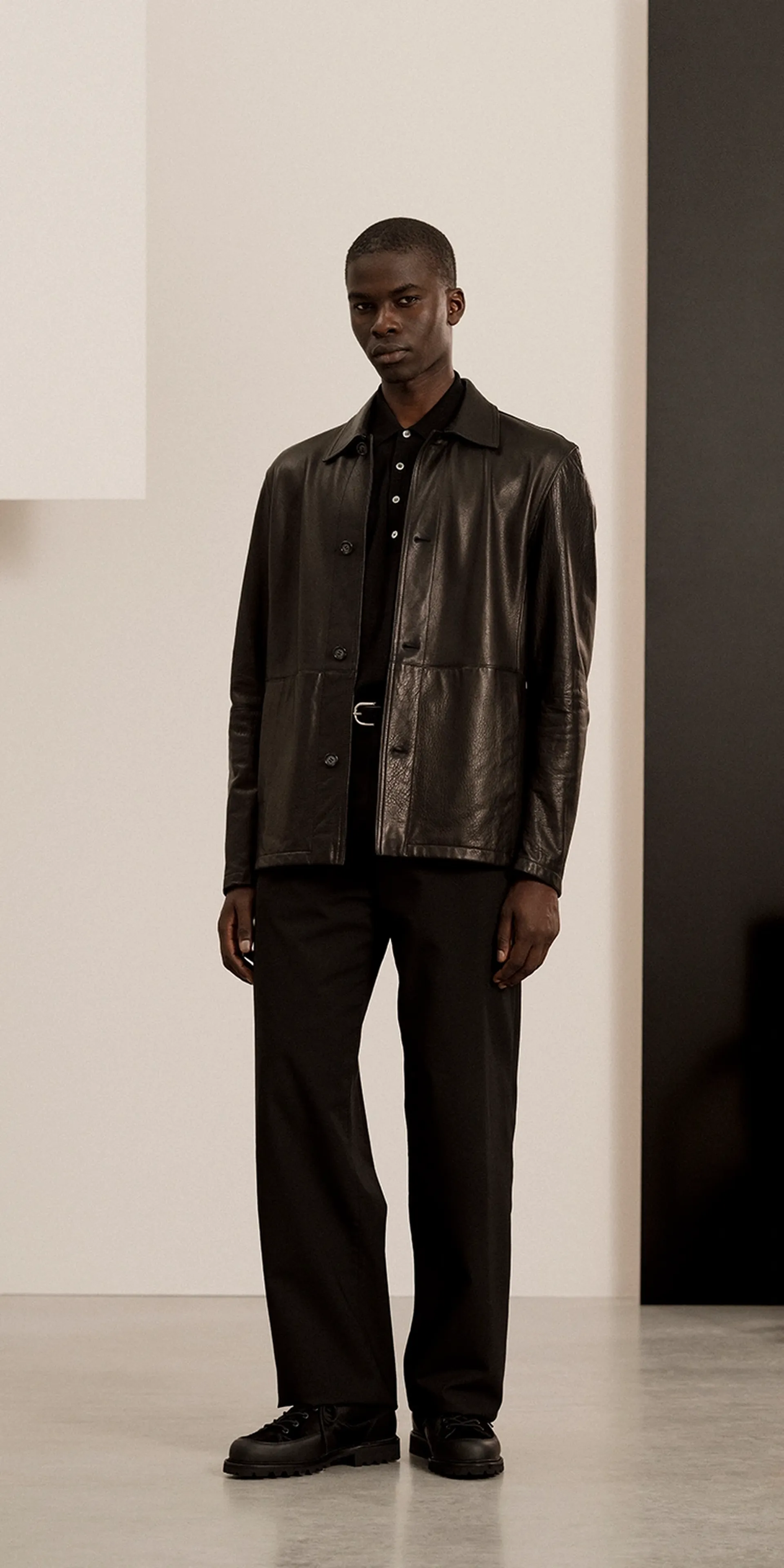 A man in a black leather jacket, and The Hiking Boot in black suede with mudguard